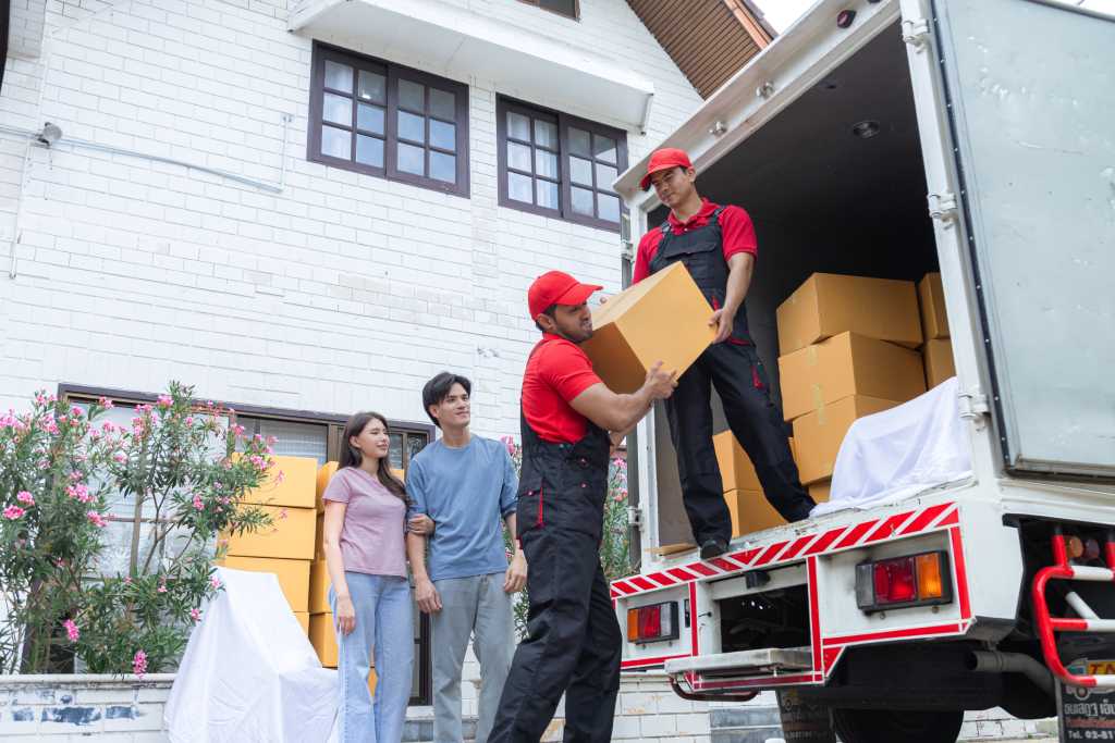 Couple watching professional movers unload