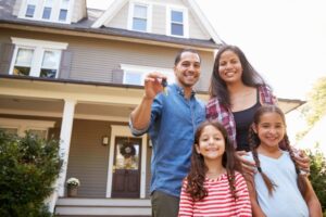 Family Holding Keys To New Home On Moving In Day